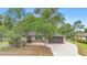 Charming home with mature trees, a well-manicured lawn and inviting facade at 1204 Lawrence Ave, Deltona, FL 32725