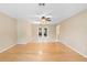 Open concept living space features hardwood floors, neutral walls, ceiling fan and glass paneled french doors at 1204 Lawrence Ave, Deltona, FL 32725