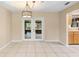 Living room with tile flooring, decorative lighting and glass paneled doors, open to kitchen at 1204 Lawrence Ave, Deltona, FL 32725