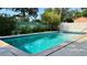 Sparkling in-ground pool with clear blue water surrounded by a patio and lush landscaping at 1301 Killian St, Daytona Beach, FL 32114