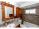 Bathroom with wooden vanity with granite top and a tub with updated tile at 136 W Gardenia Dr, Orange City, FL 32763