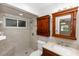 Updated bathroom featuring a tiled shower with a wooden cabinet and a vanity with a marble countertop at 136 W Gardenia Dr, Orange City, FL 32763