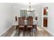 Bright dining room with wood-look floors, neutral walls, and modern lighting at 136 W Gardenia Dr, Orange City, FL 32763