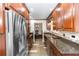 Galley style kitchen features wood cabinets, granite countertops, stainless steel appliances, and wood-look flooring at 136 W Gardenia Dr, Orange City, FL 32763