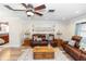 Cozy living room with wood-look floors, a ceiling fan, and a comfortable leather sofa at 136 W Gardenia Dr, Orange City, FL 32763