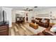 Open-concept living space with wood-look floors, a leather sofa, and access to the dining room at 136 W Gardenia Dr, Orange City, FL 32763