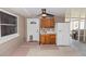 Enclosed patio area with a white refrigerator, cabinets, and view to grilling area at 136 W Gardenia Dr, Orange City, FL 32763