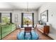 Bright living space featuring hardwood floors, a glass table, a green couch, and decoratively framed windows at 1469 Broken Oak Dr # 43A, Winter Garden, FL 34787