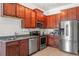Well-lit kitchen boasts stainless steel appliances and wooden cabinets, granite countertops and tile flooring at 1469 Broken Oak Dr # 43A, Winter Garden, FL 34787