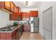 Spacious kitchen features stainless steel appliances, wooden cabinets, granite countertops and tile flooring at 1469 Broken Oak Dr # 43A, Winter Garden, FL 34787