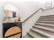 Stylish staircase with modern decor, featuring a chic side table, round mirror, and carpeted steps at 1469 Broken Oak Dr # 43A, Winter Garden, FL 34787