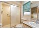 Bathroom featuring a shower with glass doors, toilet, sink, and green blinds at 1483 Meadowlark Dr, Deltona, FL 32725