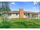 View of house showing brick chimney, gray paint, two windows, and small front yard at 1483 Meadowlark Dr, Deltona, FL 32725