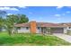 View of house showing brick chimney, gray paint, two windows, and small front yard at 1483 Meadowlark Dr, Deltona, FL 32725