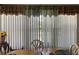 Bright dining space with large windows, cozy seating, and decorative curtains, creating a warm atmosphere at 1485 Gainsville Dr, Deltona, FL 32725