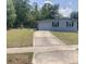 Exterior front view of home with a driveway, landscaping and well manicured lawn at 1485 Gainsville Dr, Deltona, FL 32725