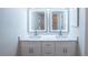 Bathroom featuring double sinks with lighted mirrors and white cabinetry at 15 Misners Trl, Ormond Beach, FL 32174