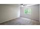 An open bedroom with natural light from the window and neutral carpet at 15 Misners Trl, Ormond Beach, FL 32174