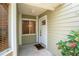 Condo entrance featuring a white door, sidelight window, and blooming plants at 15 Misners Trl, Ormond Beach, FL 32174