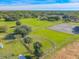 Expansive property featuring lush green fields, mature trees, and a well-maintained tennis court at 1520 Stone Trl, Enterprise, FL 32725