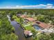 Aerial view of a home with screened pool, solar panels, fenced yard, boat dock, and water access at 1520 Stone Trl, Enterprise, FL 32725
