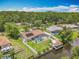 Beautiful aerial view of home featuring a screened pool, solar panels, fenced yard, boat dock and water access at 1520 Stone Trl, Enterprise, FL 32725