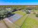 Property featuring lush greenery, mature trees, and a full-sized tennis court at 1520 Stone Trl, Enterprise, FL 32725