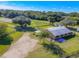 An aerial view of the house featuring a long driveway and a large barn-like structure with lots of surrounding trees at 1520 Stone Trl, Enterprise, FL 32725