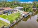 Aerial view of waterfront home with pool, boat dock, and lush landscaping at 1520 Stone Trl, Enterprise, FL 32725