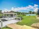 A scenic backyard featuring a charming pavilion, deck, lush lawn, and garden at 1520 Stone Trl, Enterprise, FL 32725
