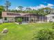 Spacious backyard featuring a pool, screen enclosure, green grass and landscaping at 1520 Stone Trl, Enterprise, FL 32725