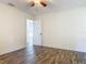 Bright bedroom showcasing a ceiling fan, trim work, and wood-look flooring at 1520 Stone Trl, Enterprise, FL 32725