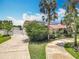 Home exterior with mature trees, solar panels and a long driveway at 1520 Stone Trl, Enterprise, FL 32725