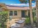 Inviting front entrance with blue door, brick accents, lush landscaping, and solar panels on the roof at 1520 Stone Trl, Enterprise, FL 32725