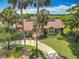 Beautiful front yard featuring lush landscaping and a circular driveway leading to a home with solar panels at 1520 Stone Trl, Enterprise, FL 32725
