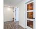Hallway with wood-look floors, doors, and access to a closet with shelving at 1520 Stone Trl, Enterprise, FL 32725
