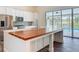 Modern kitchen featuring white cabinets, stainless steel appliances, and a wood-topped island at 1520 Stone Trl, Enterprise, FL 32725