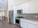 Well-equipped kitchen with stainless steel appliances, stylish backsplash, and ample white cabinetry at 1520 Stone Trl, Enterprise, FL 32725