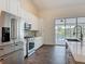 Bright kitchen features stainless steel appliances, white cabinets, and views of the screened outdoor pool at 1520 Stone Trl, Enterprise, FL 32725