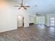 Bright open-concept living area with vaulted ceiling, ceiling fans, and wood-look tile flooring at 1520 Stone Trl, Enterprise, FL 32725