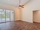 Large living room with fan and sliding glass door that leads to pool and screened enclosure at 1520 Stone Trl, Enterprise, FL 32725