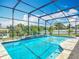 Inviting screened-in pool with clear blue water, waterfall features, and lush landscaping at 1520 Stone Trl, Enterprise, FL 32725