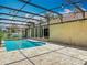 A refreshing swimming pool is surrounded by a screened enclosure and stone pavers for relaxing outdoors at 1520 Stone Trl, Enterprise, FL 32725