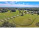 Well-maintained grass riding arena and surrounding land with mature trees and a nearby pond at 1520 Stone Trl, Enterprise, FL 32725