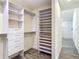 Custom walk-in closet with built-in shelving and drawers, leading to ensuite bathroom with shower at 1520 Stone Trl, Enterprise, FL 32725