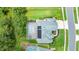 Aerial view of the property featuring a screened pool, solar panels, beautiful landscaping, and well-manicured lawn at 1910 Creekwater Blvd, Port Orange, FL 32128