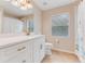 Bathroom featuring white vanity with marble countertop, a framed window, and a shower with white curtain at 1910 Creekwater Blvd, Port Orange, FL 32128