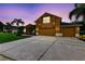 Exterior view featuring a well-manicured lawn, palm trees, three-car garage, and spacious concrete driveway at 1910 Creekwater Blvd, Port Orange, FL 32128