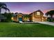Charming exterior view showcasing a well-maintained lawn, palm trees, colorful front door, and three car garage at 1910 Creekwater Blvd, Port Orange, FL 32128