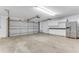 Spacious garage with ample room for vehicles and storage with a refrigerator and white cabinetry at 1910 Creekwater Blvd, Port Orange, FL 32128